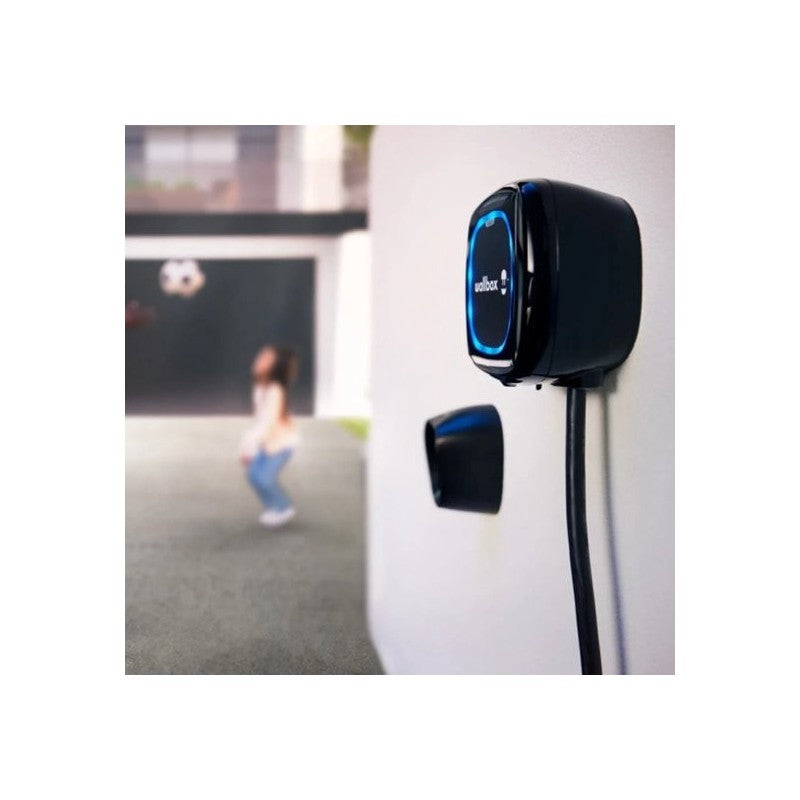 Schwarze Wallbox Pulsar Max Ladestation für Elektroautos an einer Wand installiert; Katalogbild in einer Anwendungssituation.
